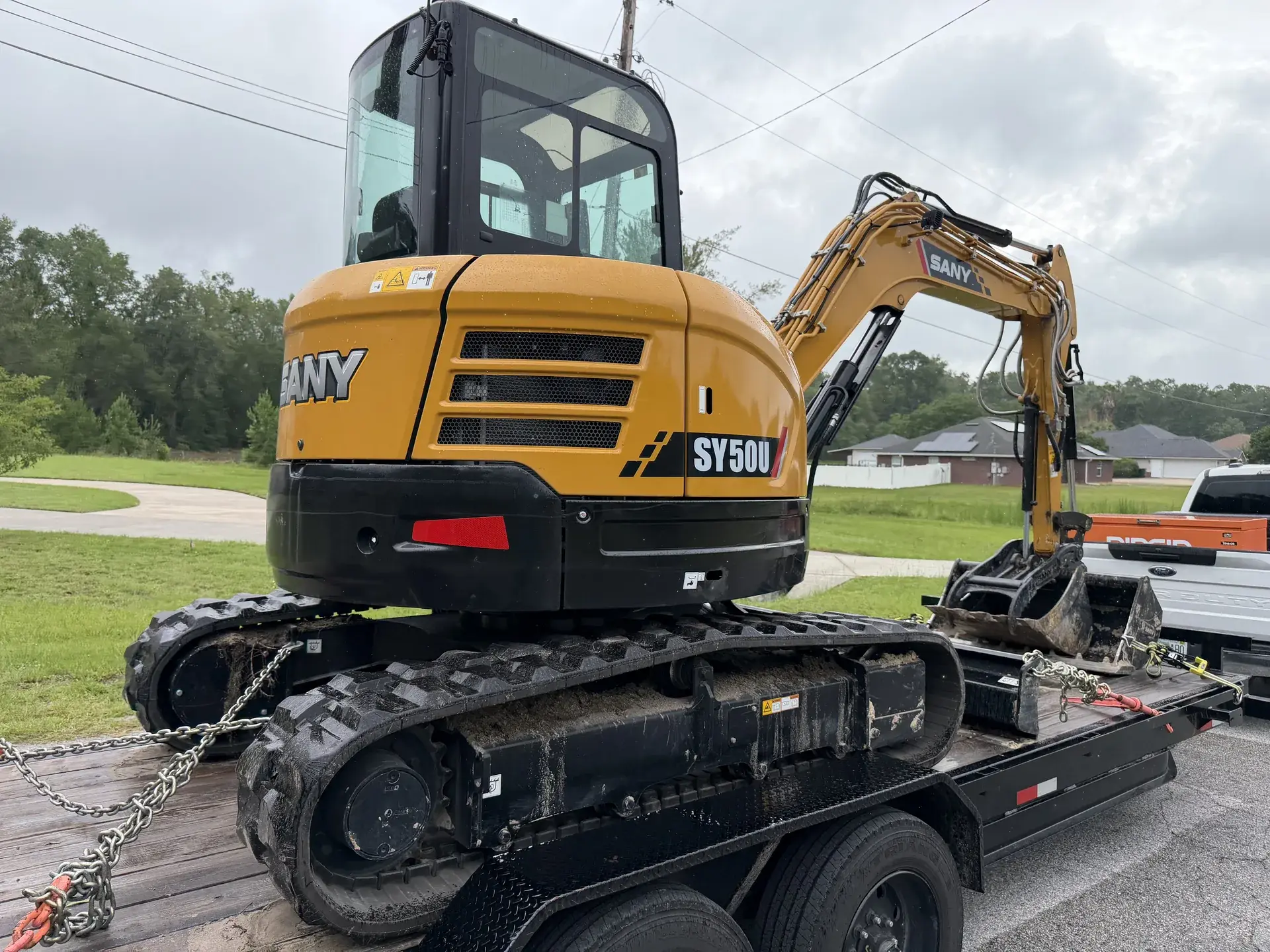 Falcon compact excavator secured on an equipment trailer.